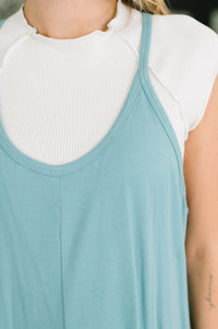 Person wearing a light blue tank top over a white turtleneck
