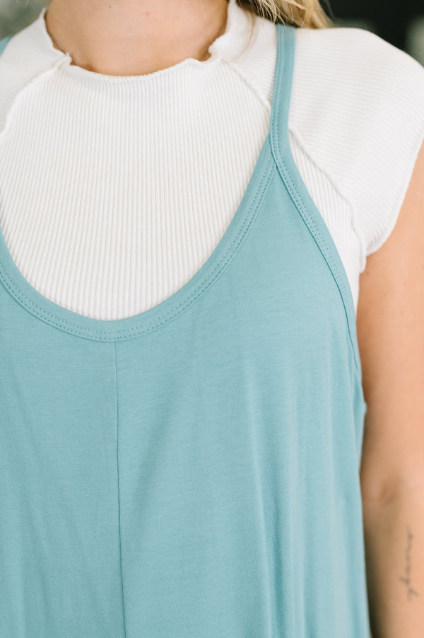 Person wearing a light blue tank top over a white turtleneck