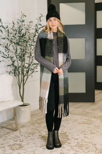 Woman wearing a long plaid scarf in a modern living room setting