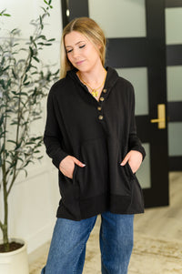 Woman wearing a black cardigan with buttons in an indoor setting