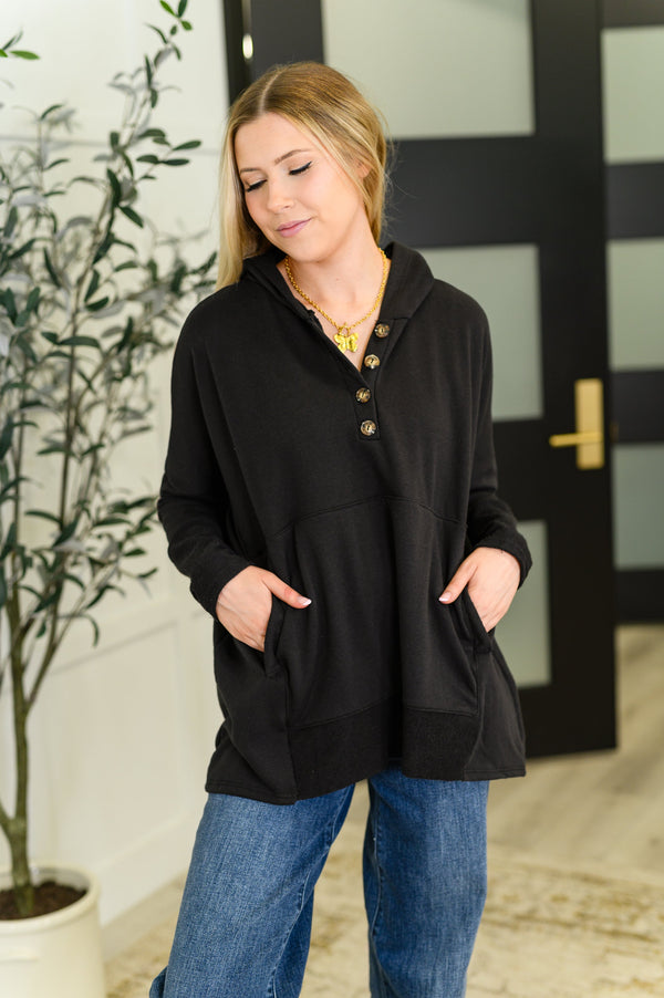Woman wearing a black cardigan with buttons in an indoor setting