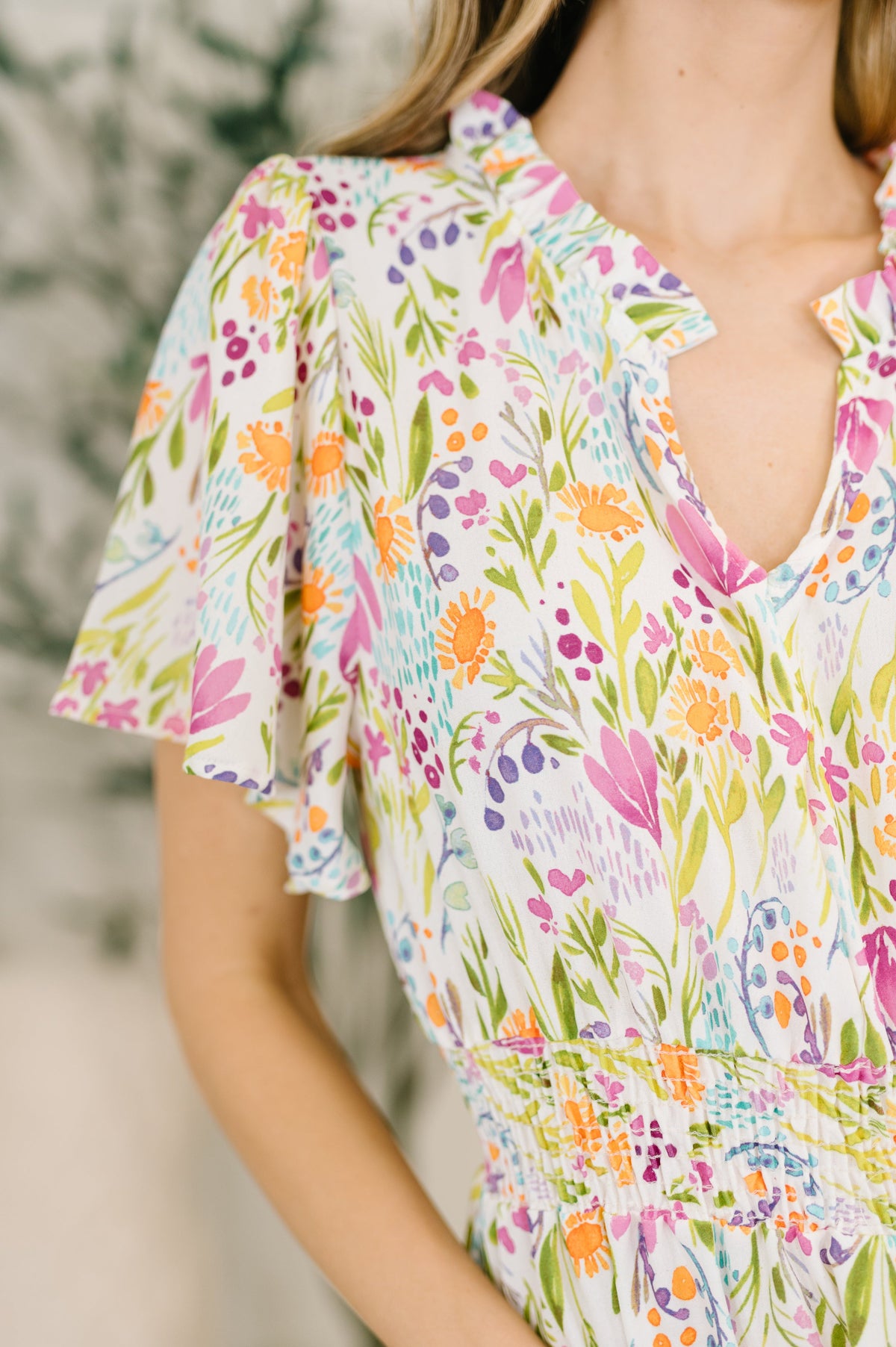 Multicolored floral dress worn by a person with a blurred background